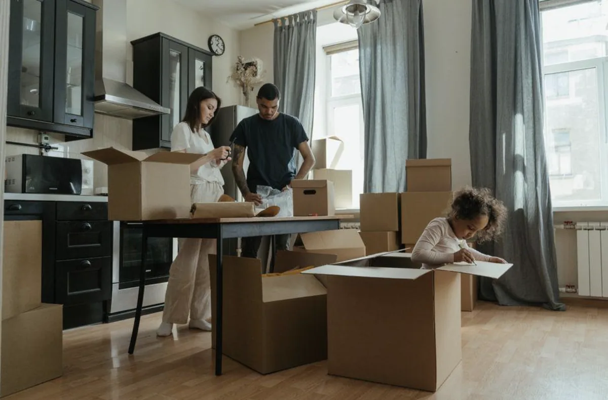A family packing cardboard boxes in their kitchen during a move