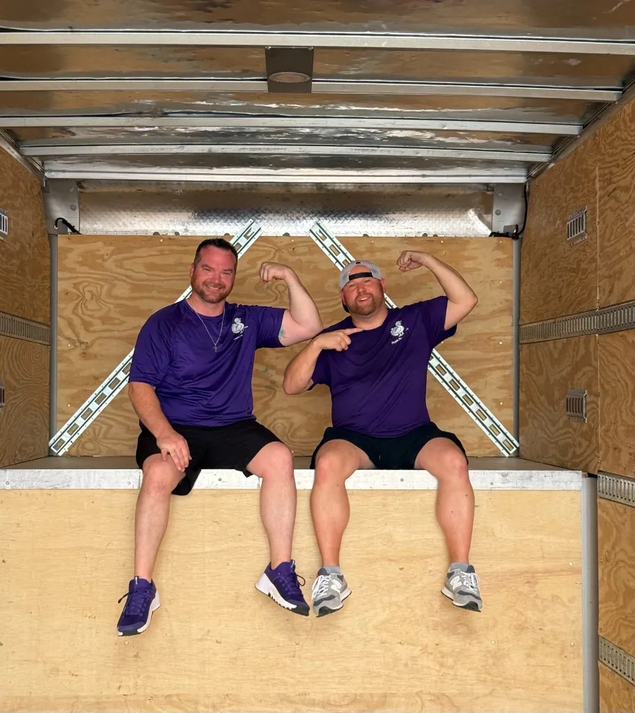 Derik and Chris flexing inside an empty Purple Peacock moving truck